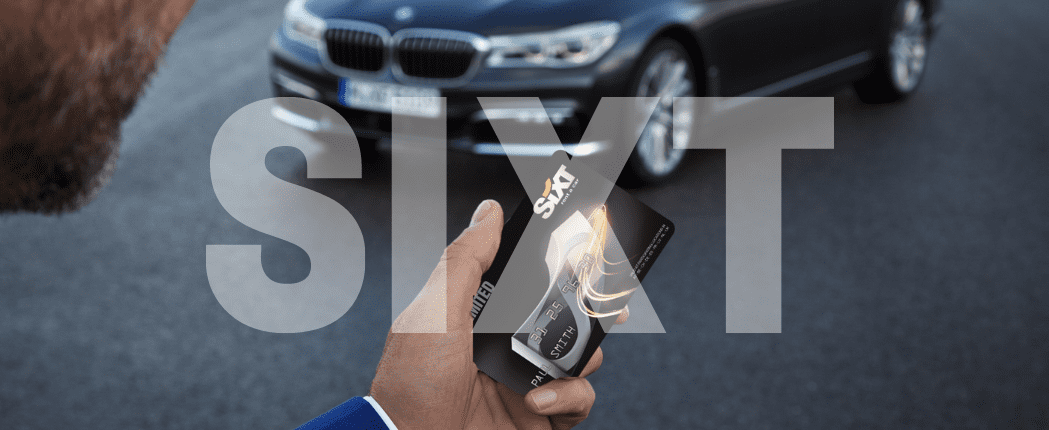 Ein SIXT Firmenkunde mit seiner Loyalty Card vor einem schwarzen Mercedes