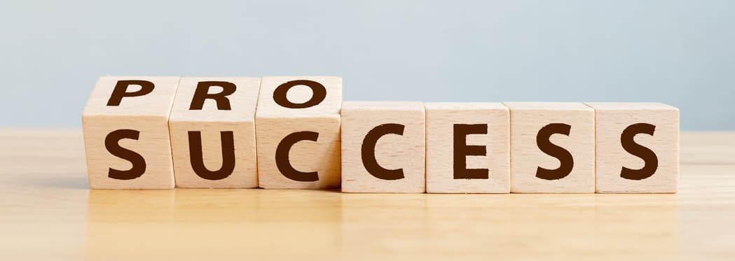 Wooden blocks uncovering the word success in business