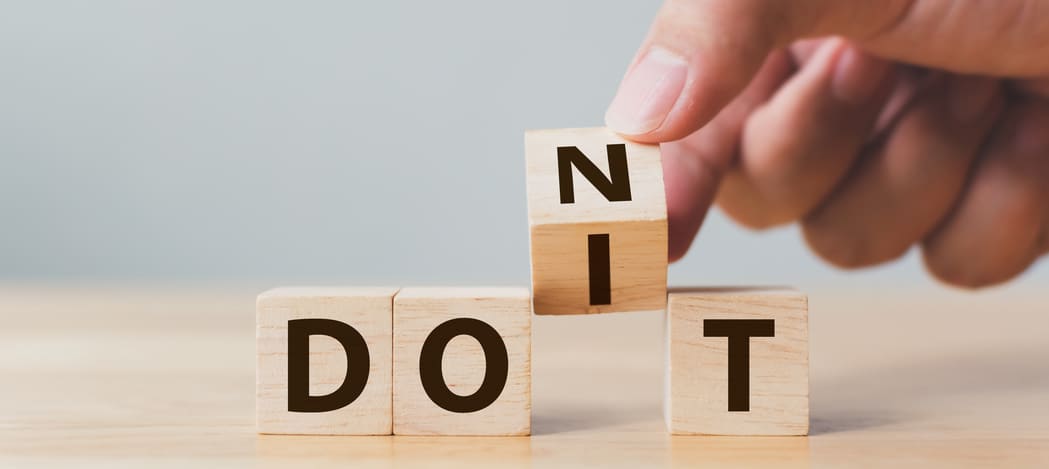 A business man uncovering wooden blocks with the words dos to reach a successful business